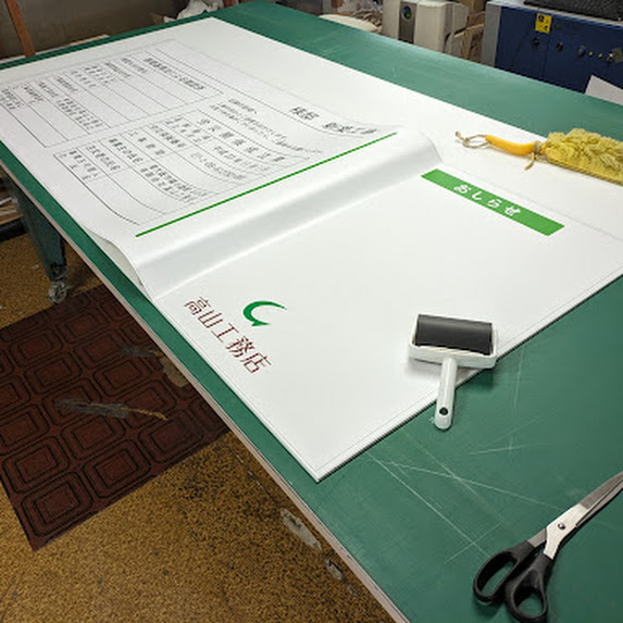 ラミネート加工した印刷シート貼って住宅工事看板を製作中