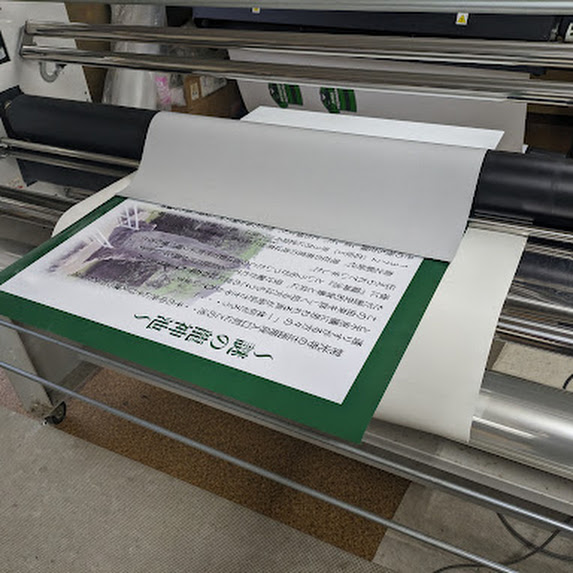 印刷をシートをラミネート機で貼ってアルミ複合板看板を製作