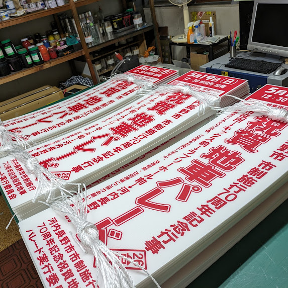 穴あけしヒモを付けたお祭り告知用のプラダン看板