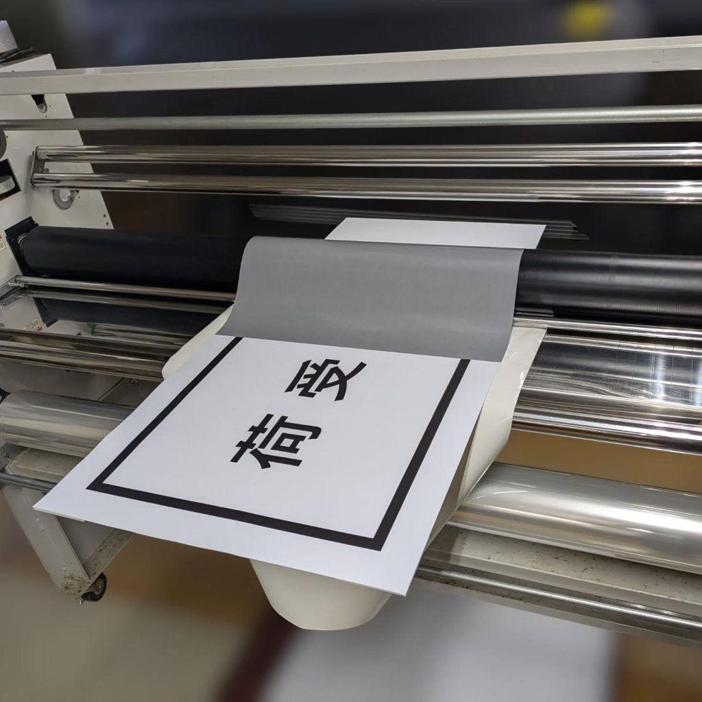 印刷シートをラミネート機を使ってアルミ複合板に貼る